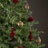 Julgranskulor i glas klädd med röd velvet
