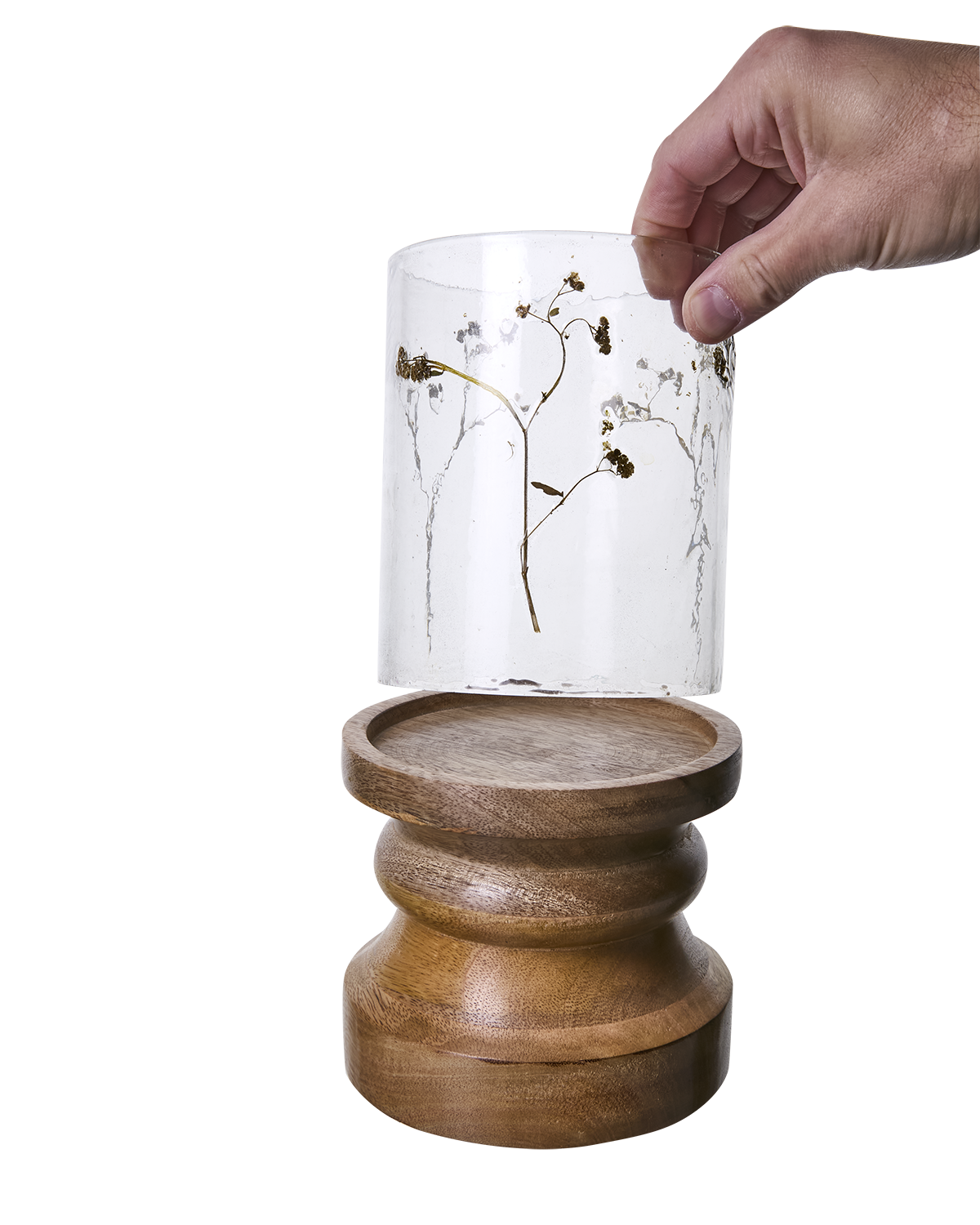Ljuslykta i klarglas med blommor på träfot