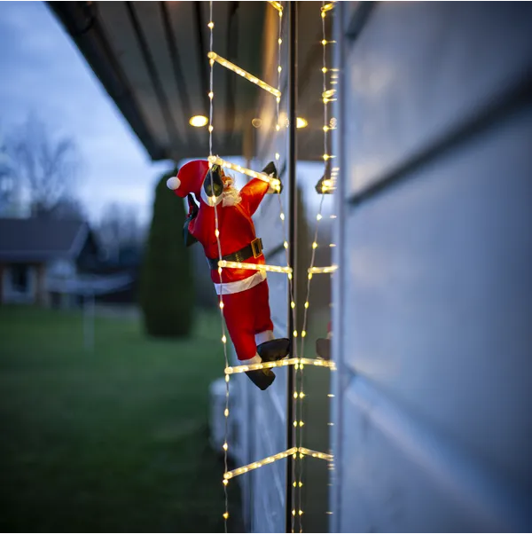 klättrande tomte på stege med ljusslinga för utomhusbruk
